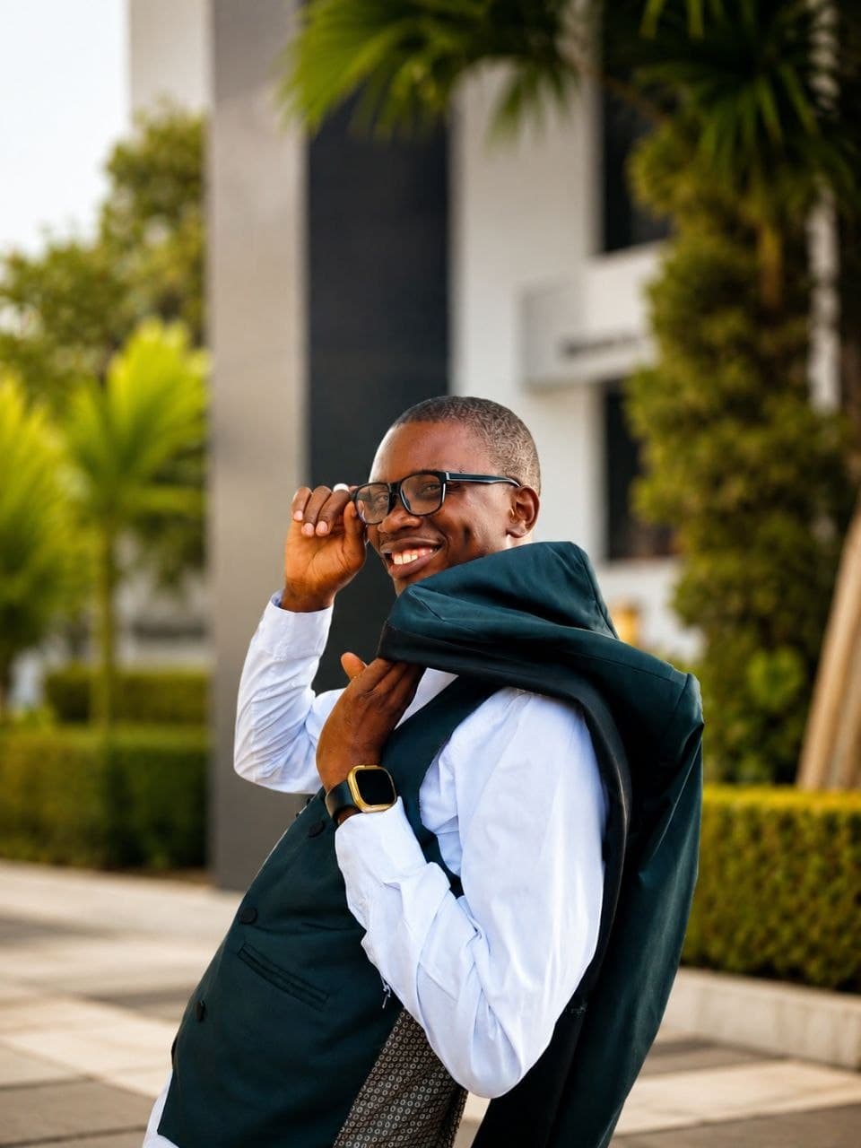 Gabriel outdoors, jacket over one shoulder